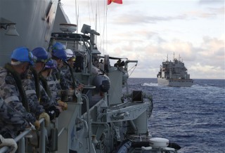 A group of Royal Australian Navy sailors aboard the Royal Australian Navy frigate HMAS Perth awaits Military Sealift Command dry cargo and ammunition ship USNS Cesar Chavez, right, at the start of a replenishment-at-sea in the Indian Ocean, April 12, 2014. The Perth is participating in the search for missing Malaysia Airlines Flight MH370. Royal Australian Navy photo by Able Seaman Imagery Specialist Nicolas Gonzalez