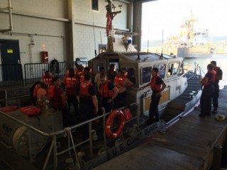 Coast Guard crew members stand with 11 survivors of the Tug Nalani at Coast Guard Station Honolulu.